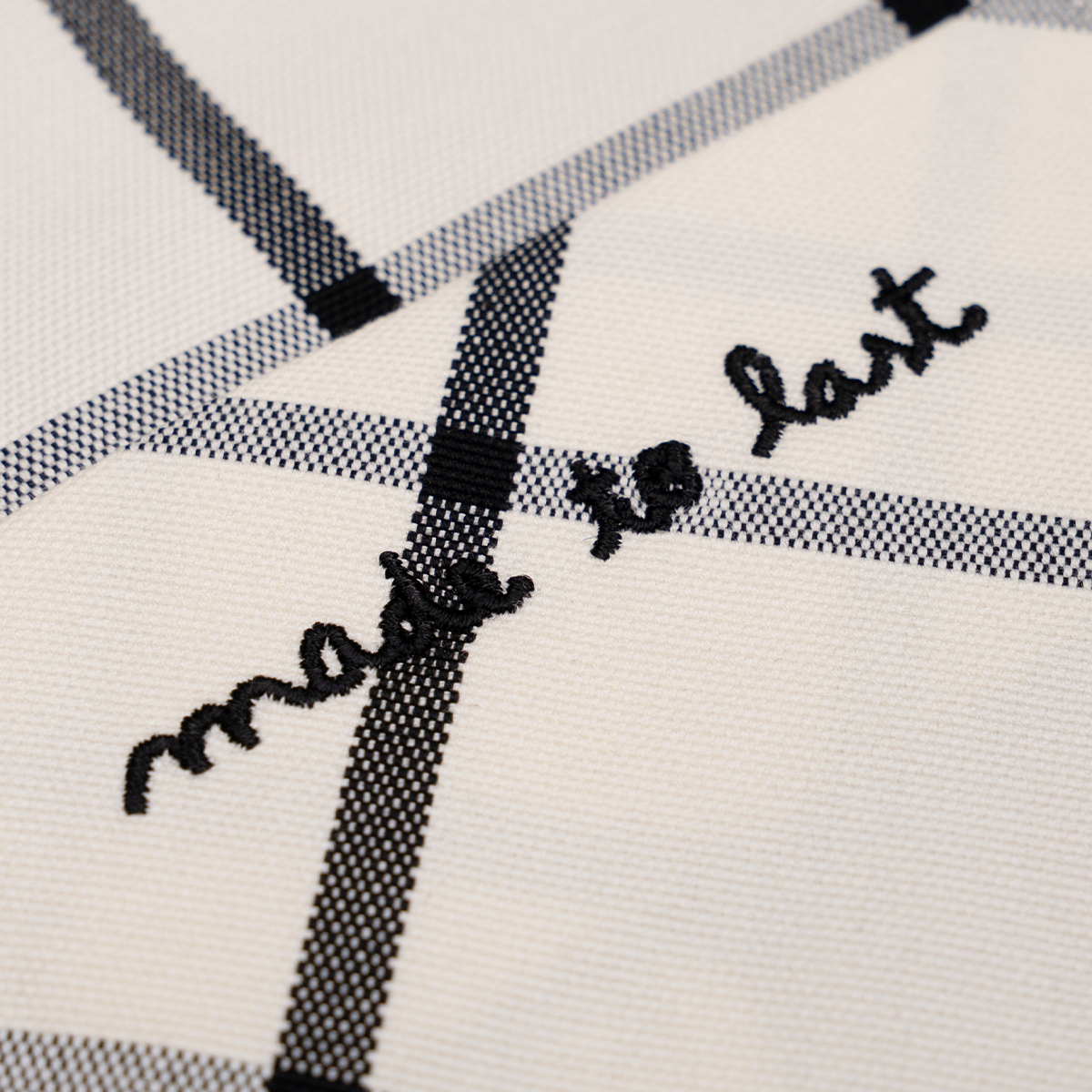 Embroidered 'made to last' on a checkered fabric