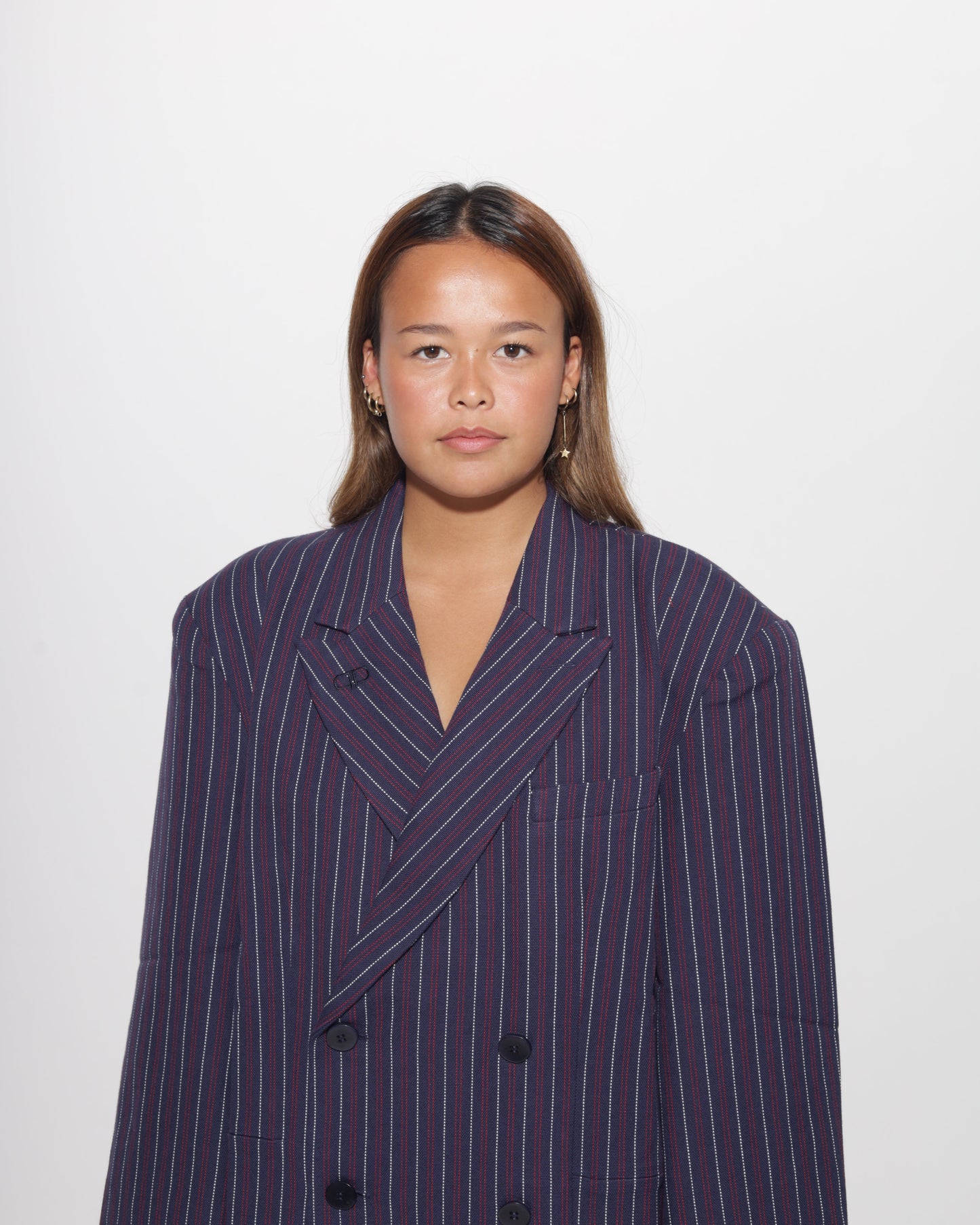 Person wearing a dark blue pinstripe blazer on a white background