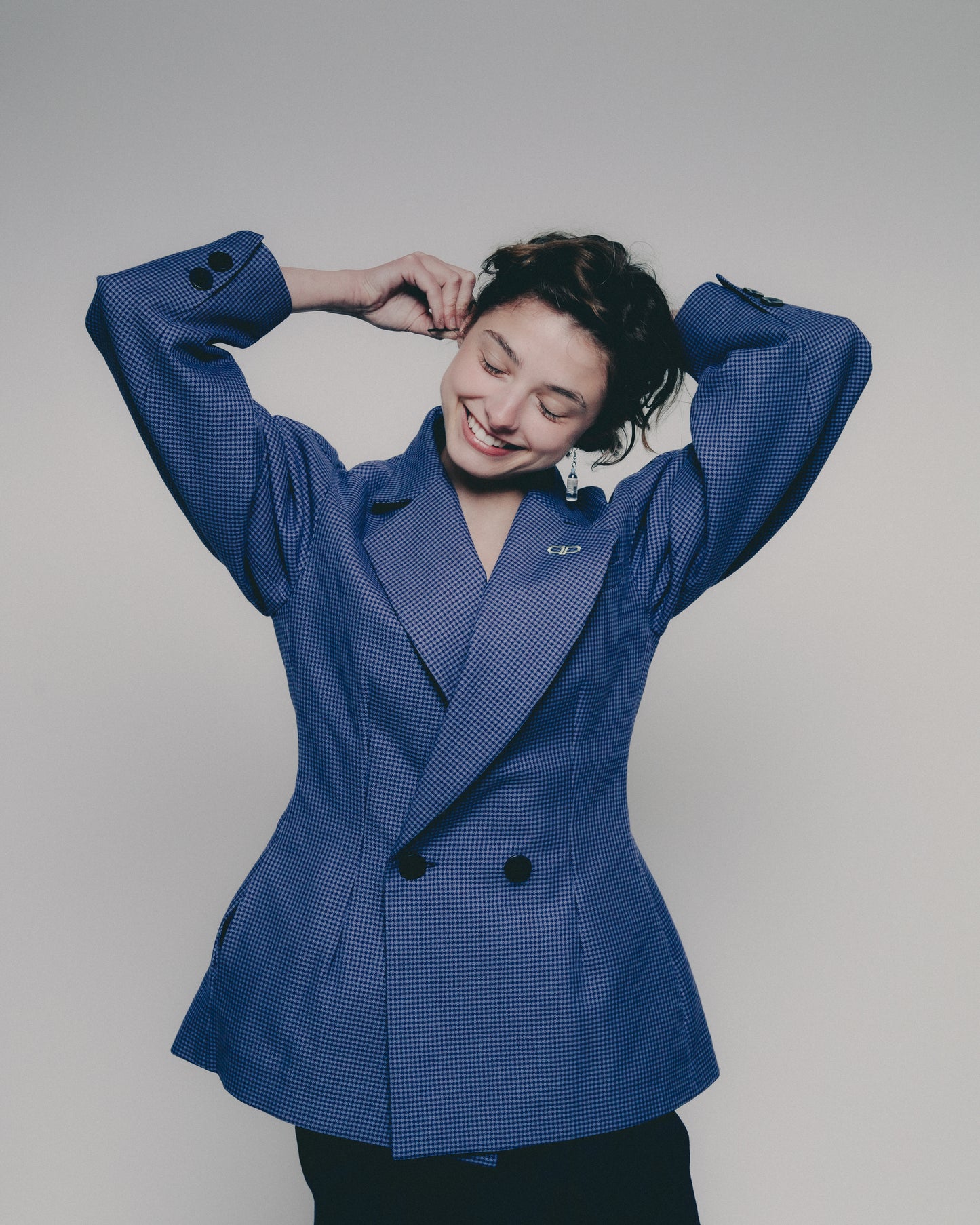 Person wearing a blue blazer against a plain background