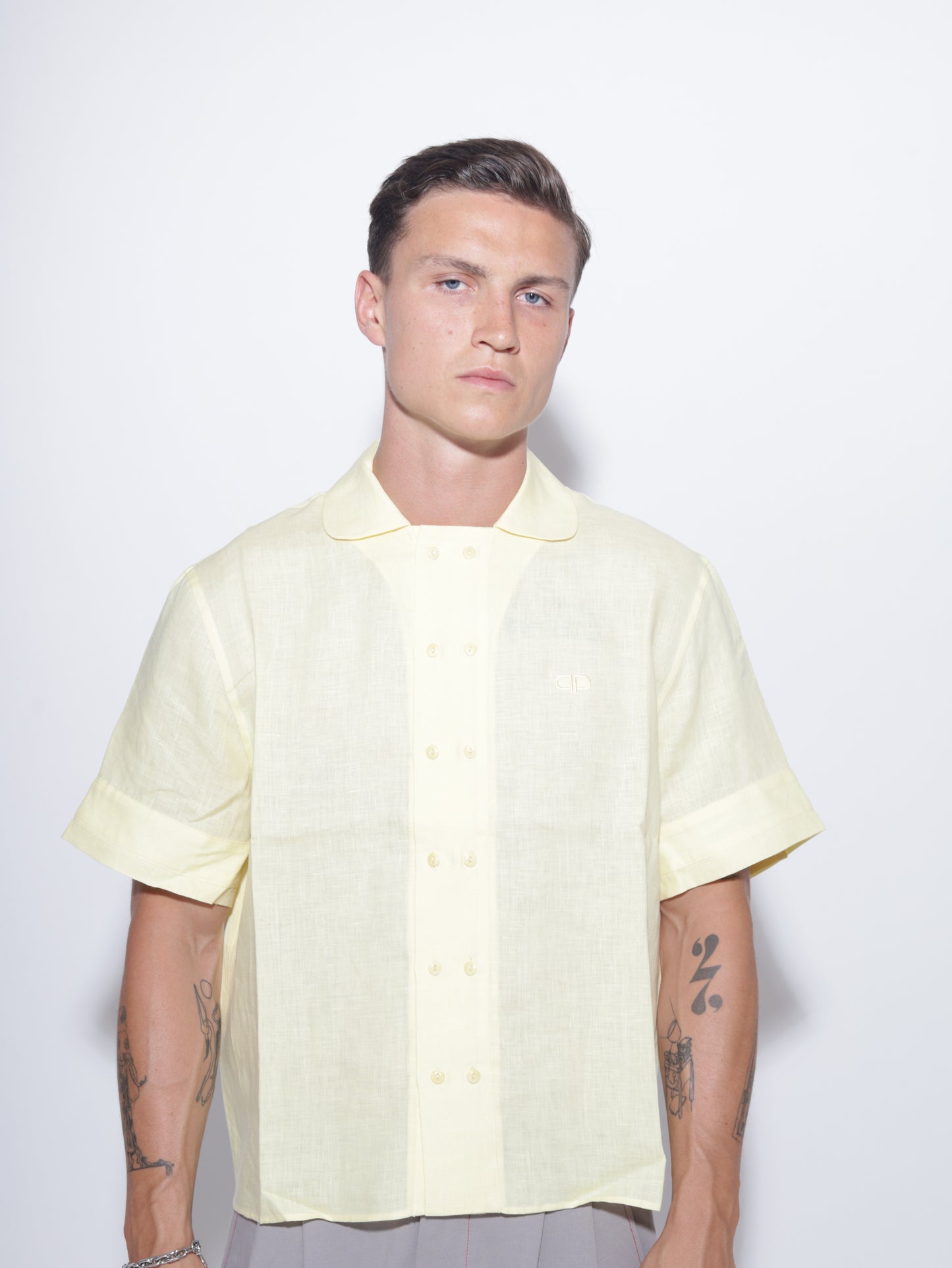 Person wearing a light yellow shirt on a white background