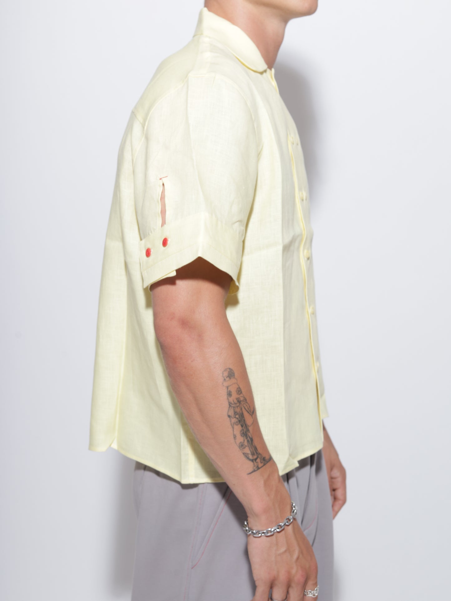 Person wearing a yellow shirt with a cutout design on a plain background