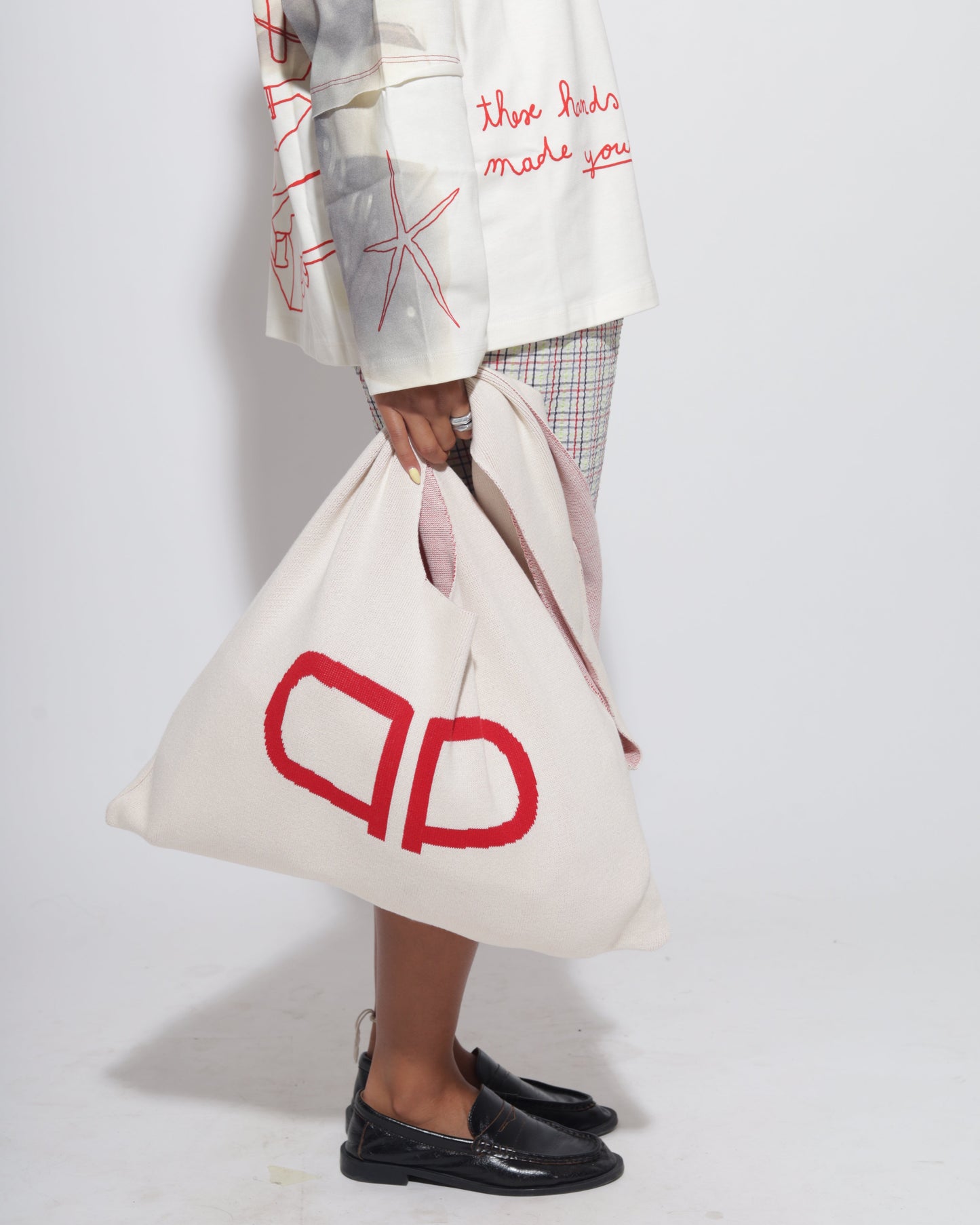 Person holding a white bag with red logo.