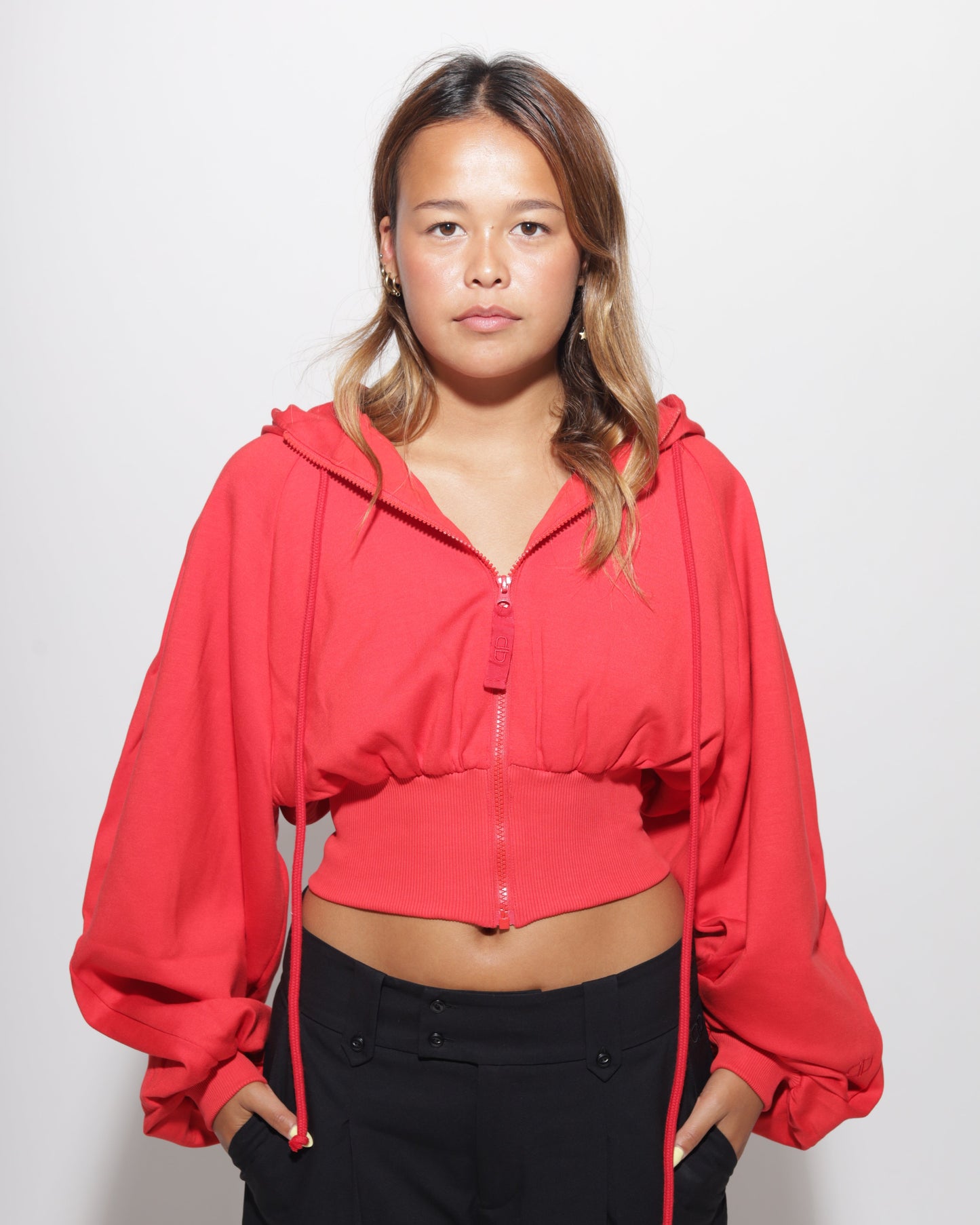 Person wearing a red hoodie on a white background