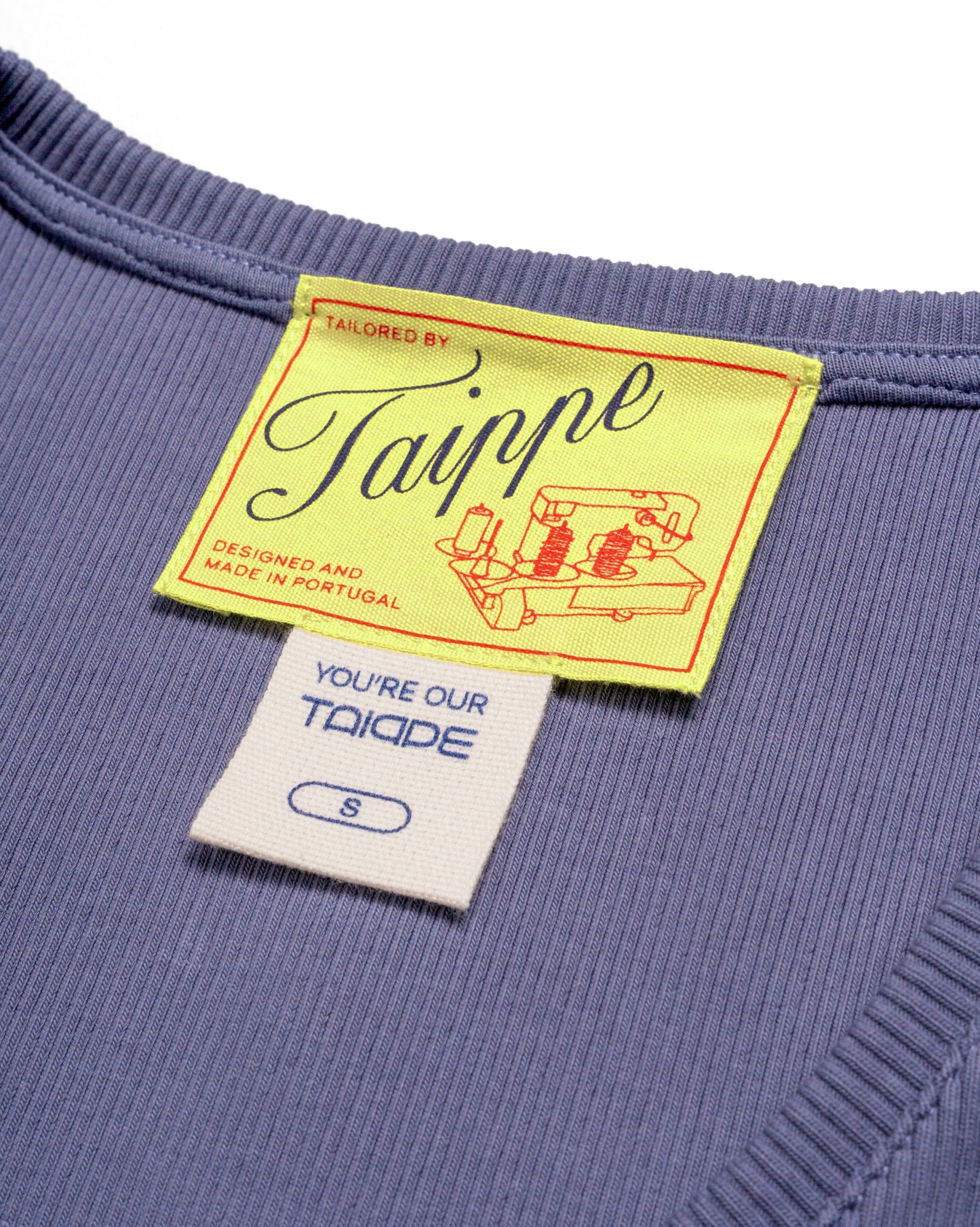 Close-up of a blue tank top with a yellow tag featuring the brand 'Taippe'.