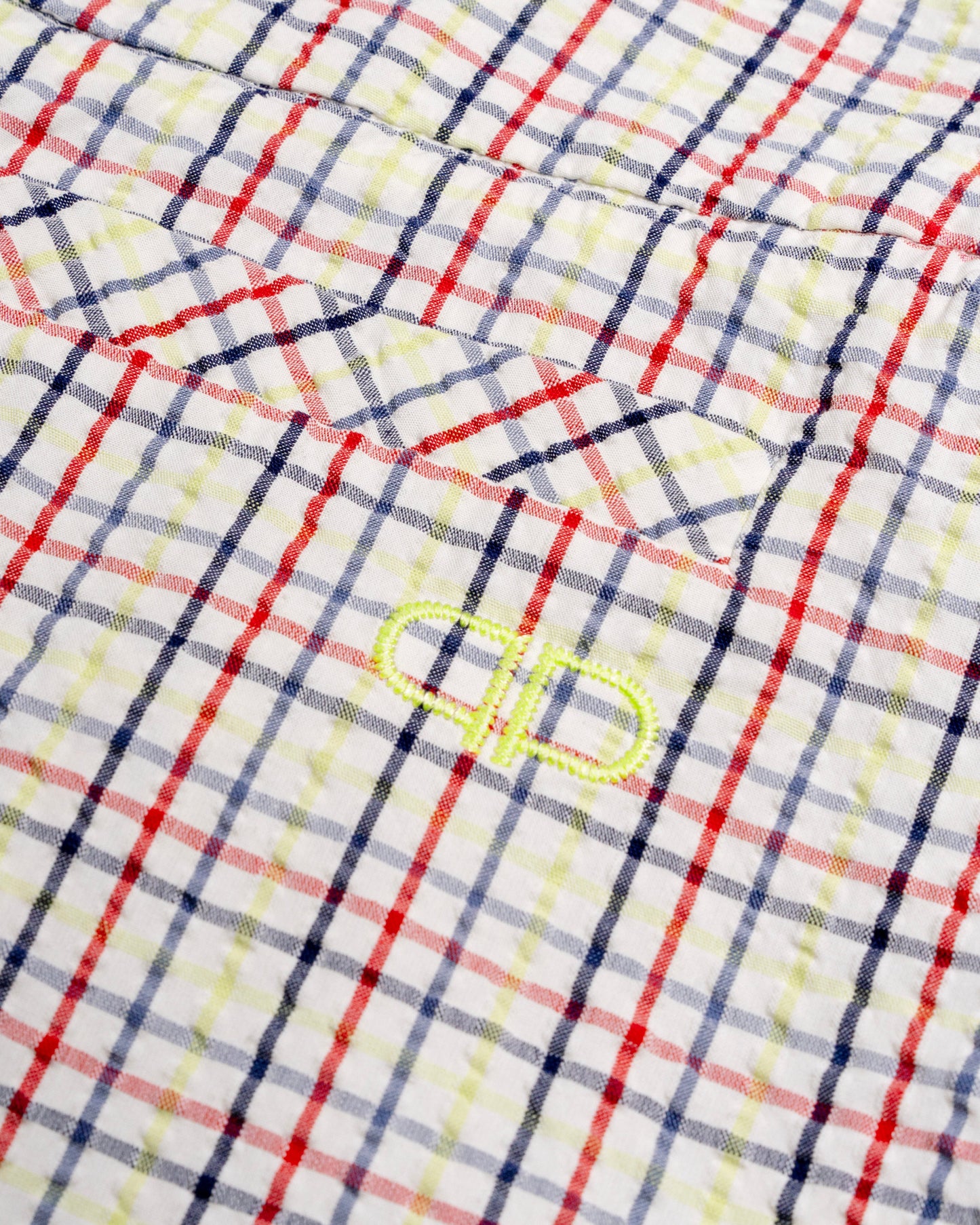 Close-up of a checkered capris with a brand logo