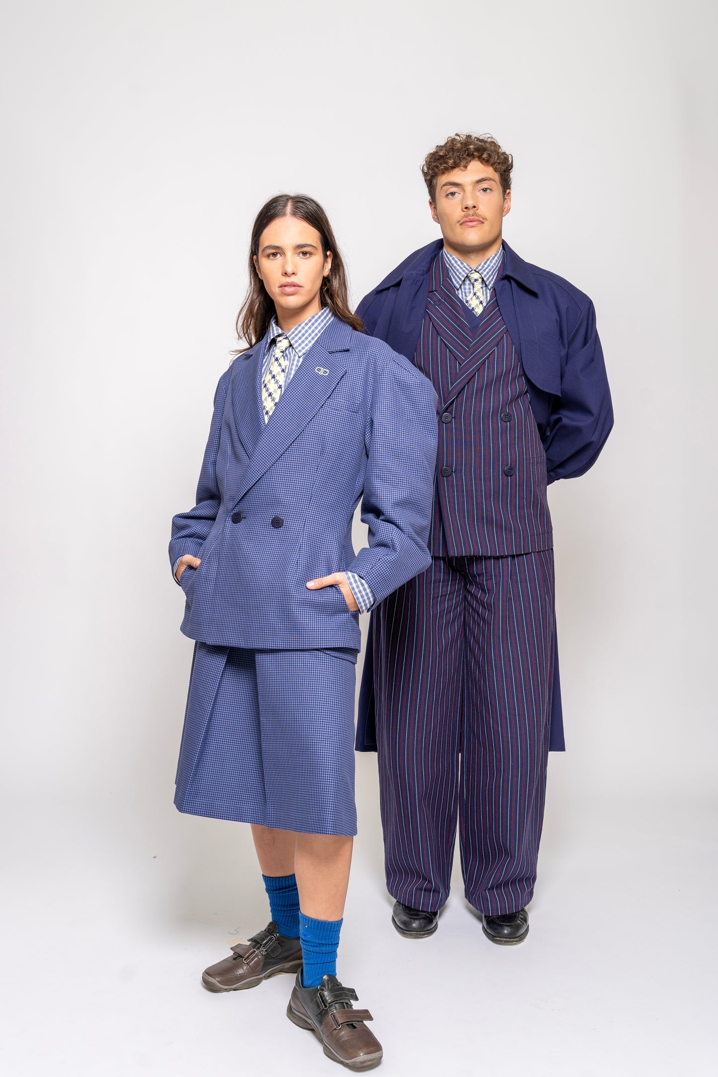Two people wearing coordinated blue outfits on a white background