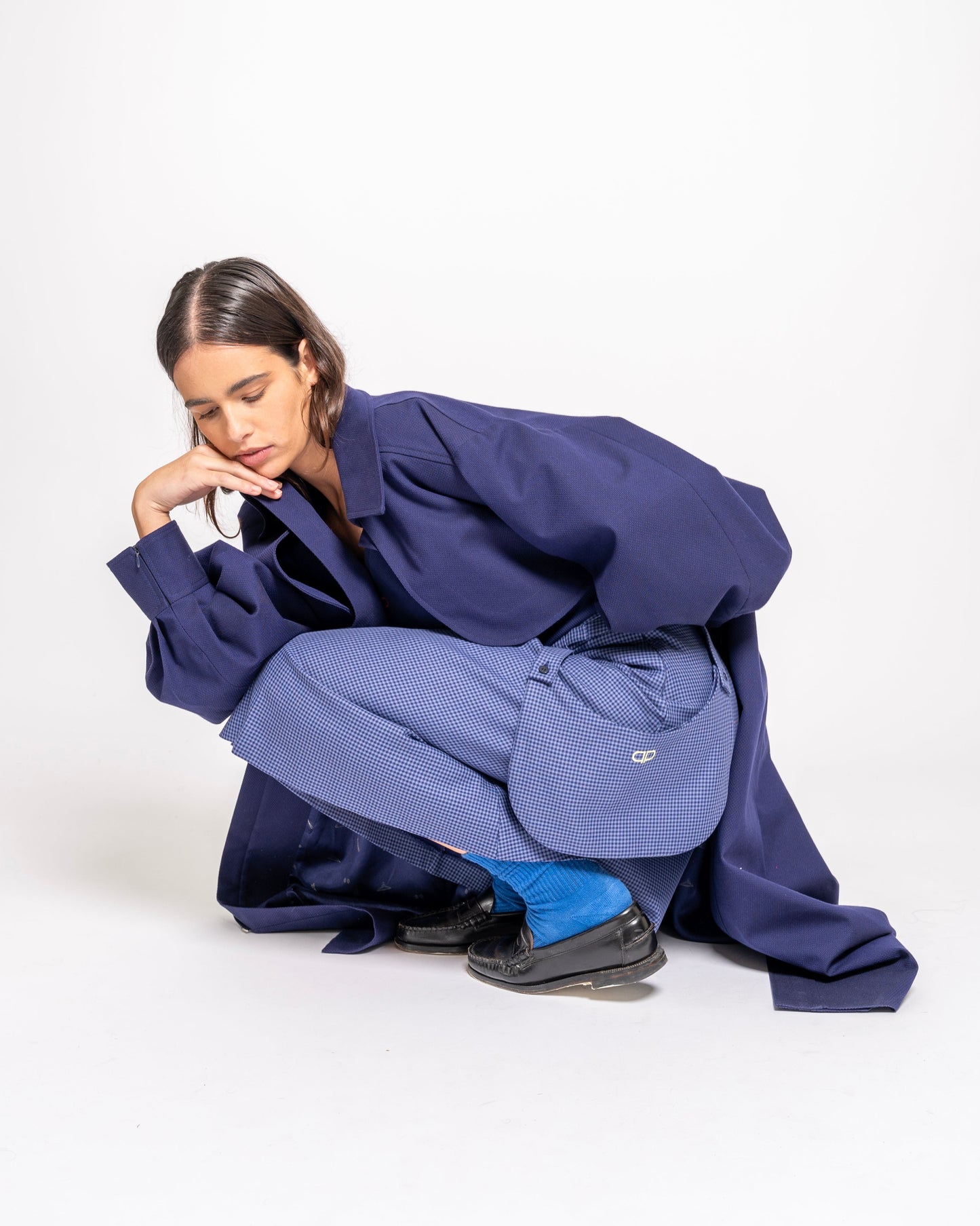 Person wearing a blue skirt with external pockets on a white background