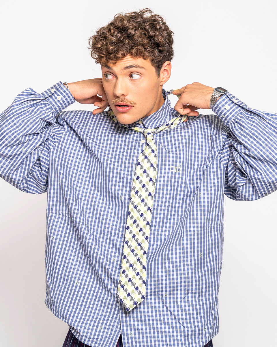 Man adjusting a patterned tie on a white background