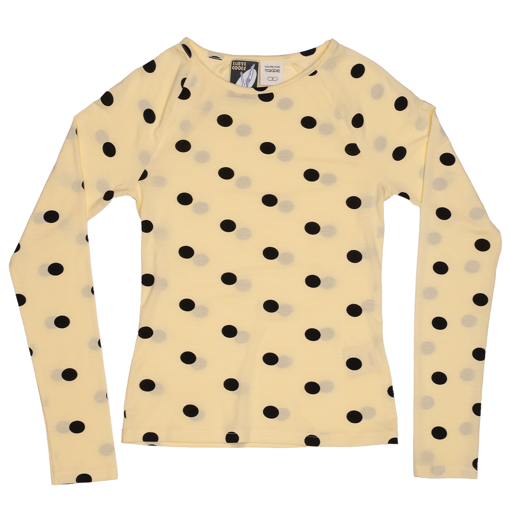 Yellow long-sleeve top with black polka dot pattern on a white background