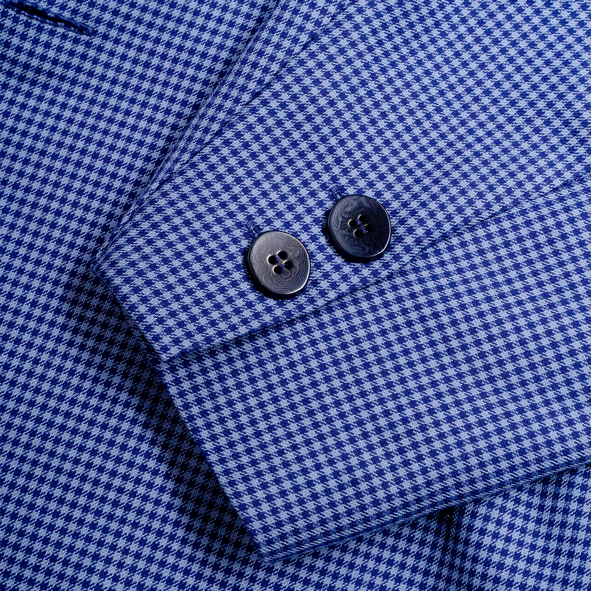 Close-up of a blue checkered blazer with a button 
