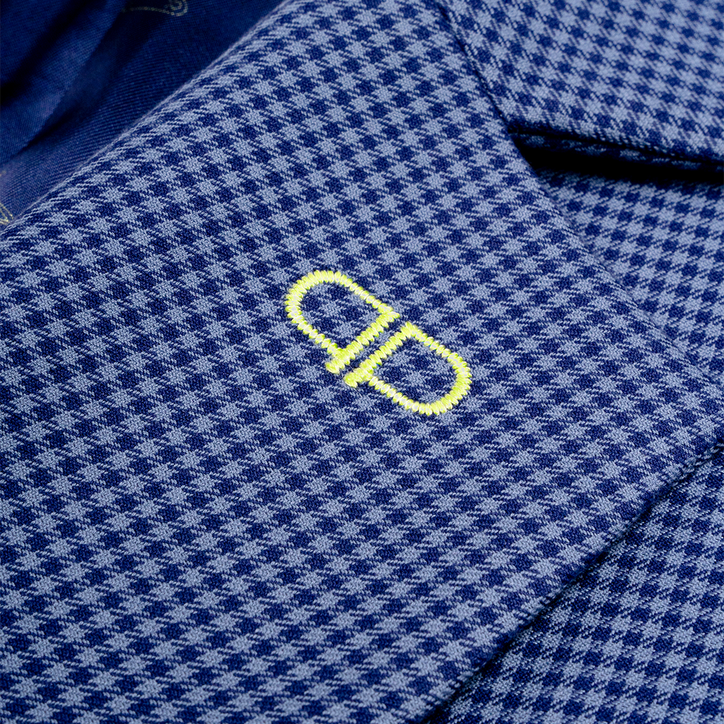Close-up of a blue checkered blazer with a yellow logo 