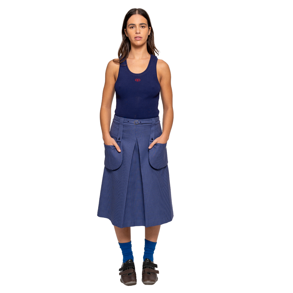 Woman wearing a navy tank top and blue skirt on a white background