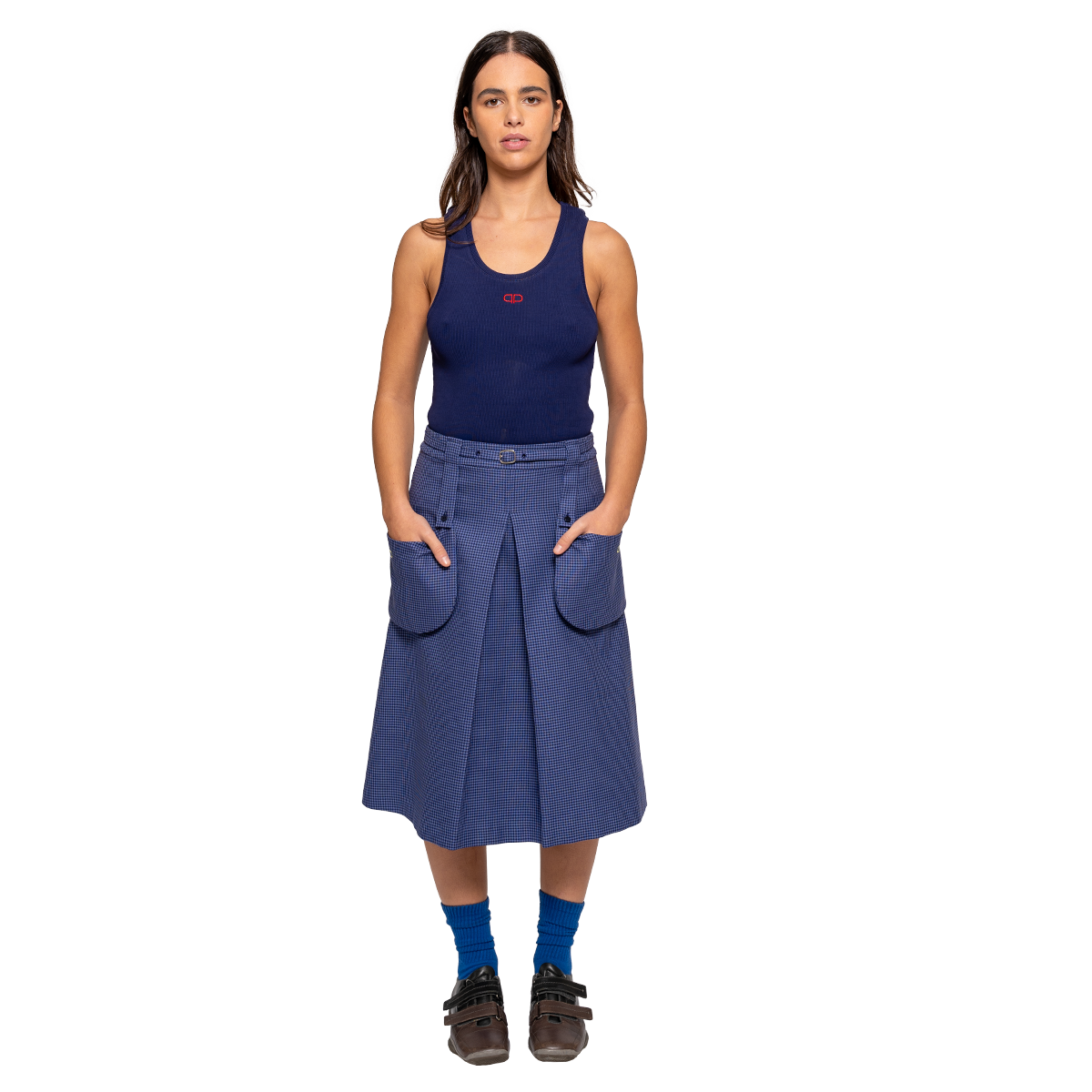 Woman wearing a navy tank top and blue skirt on a white background