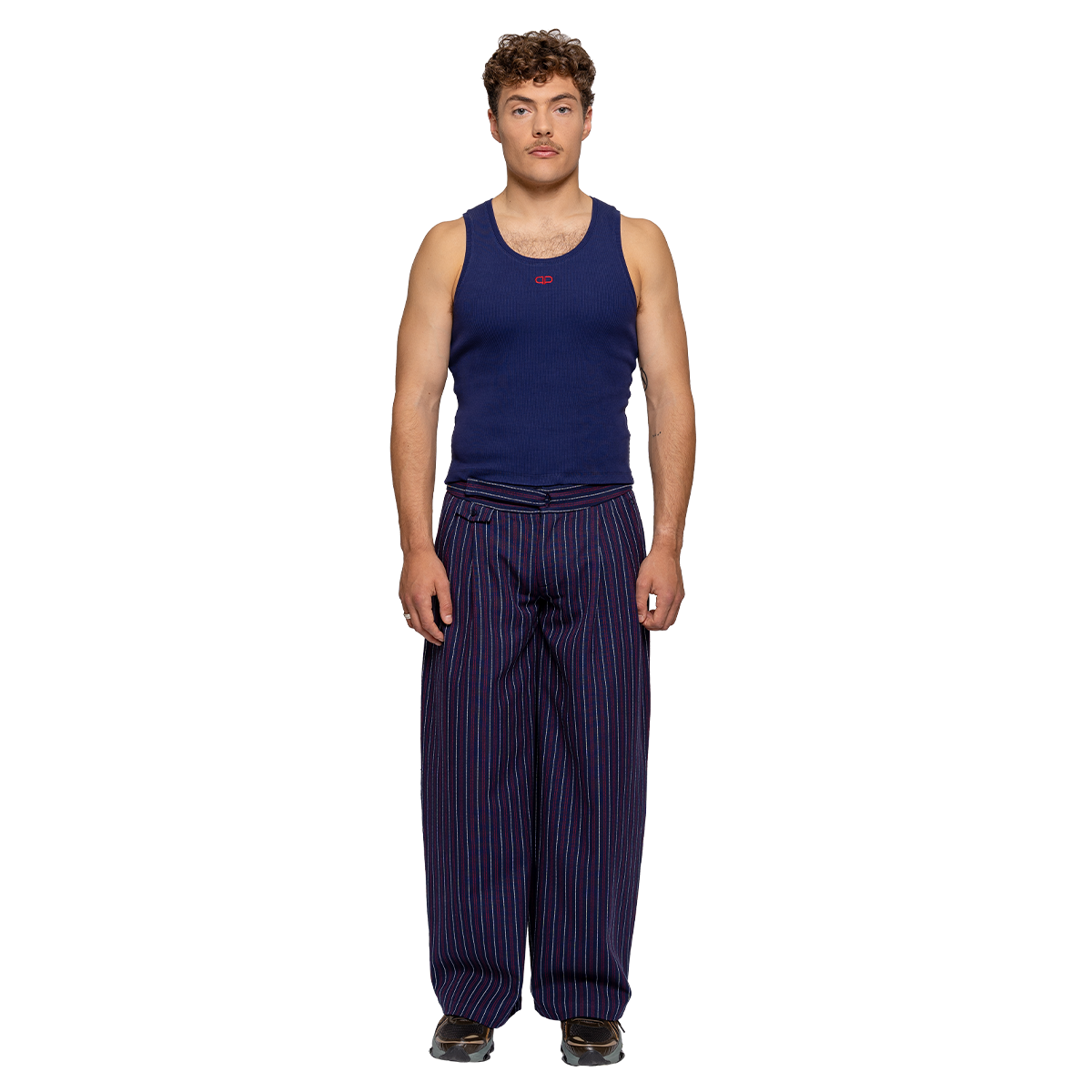 Man wearing a navy tank top and striped pants on a white background