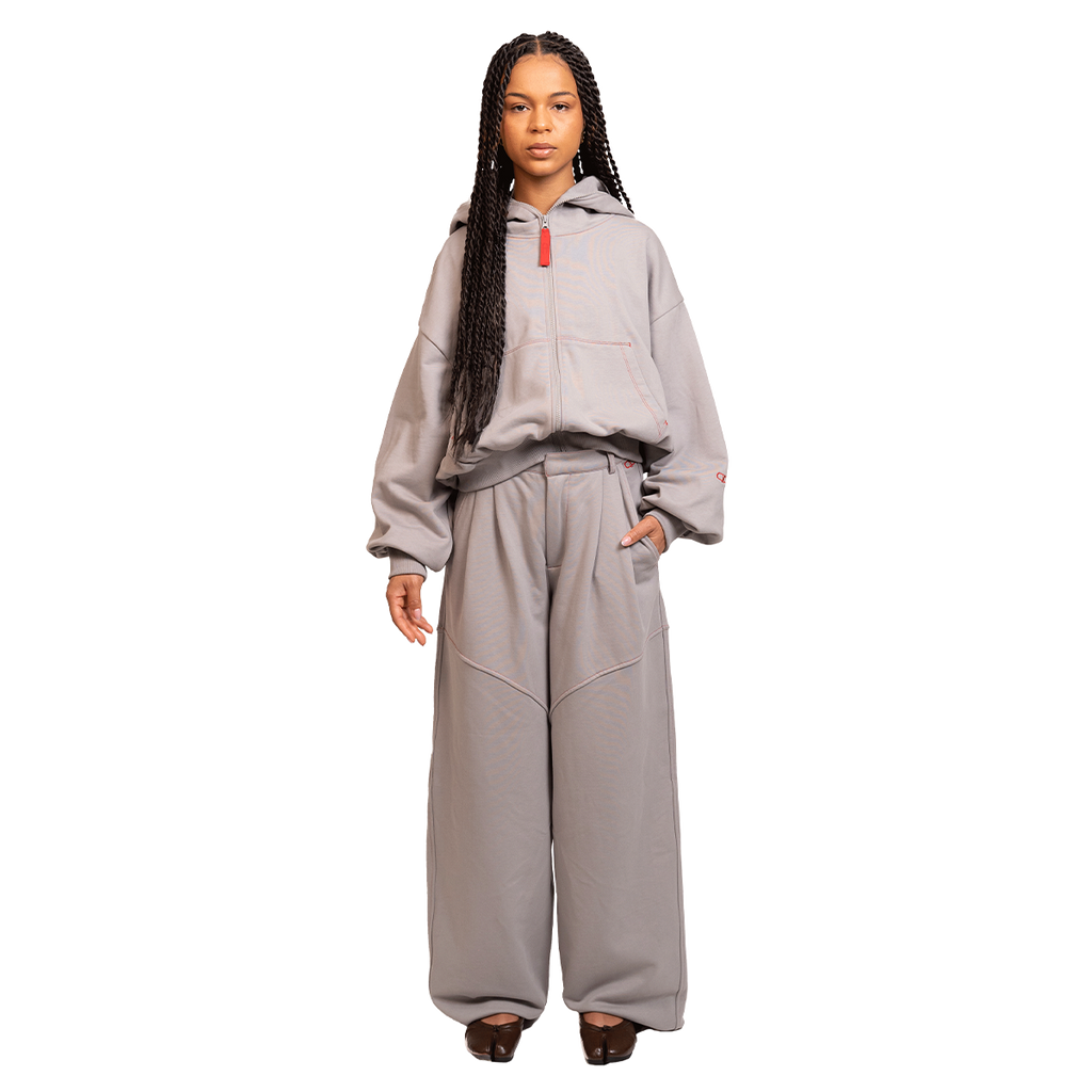 Person wearing a gray tracksuit on a white background