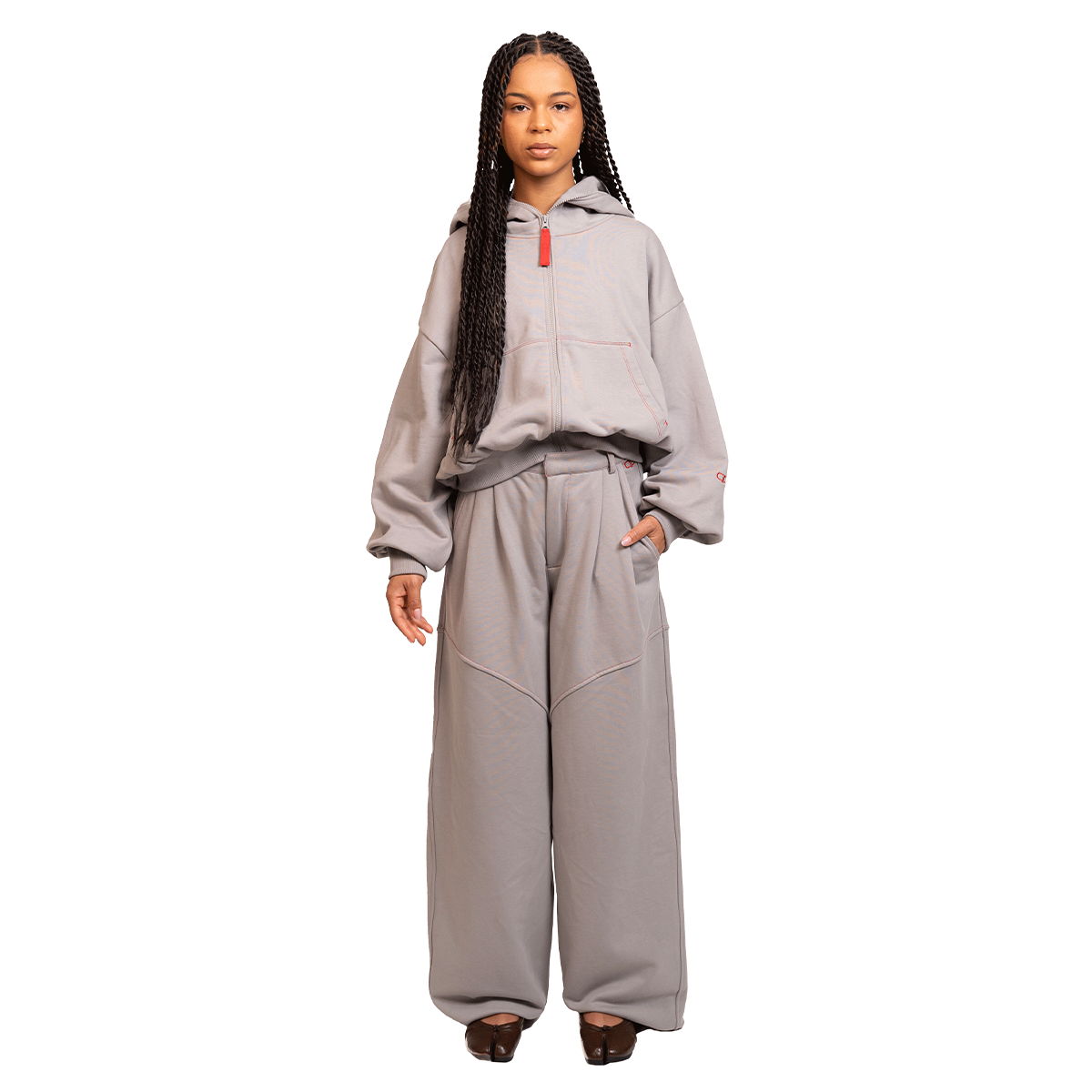 Person wearing a gray tracksuit on a white background