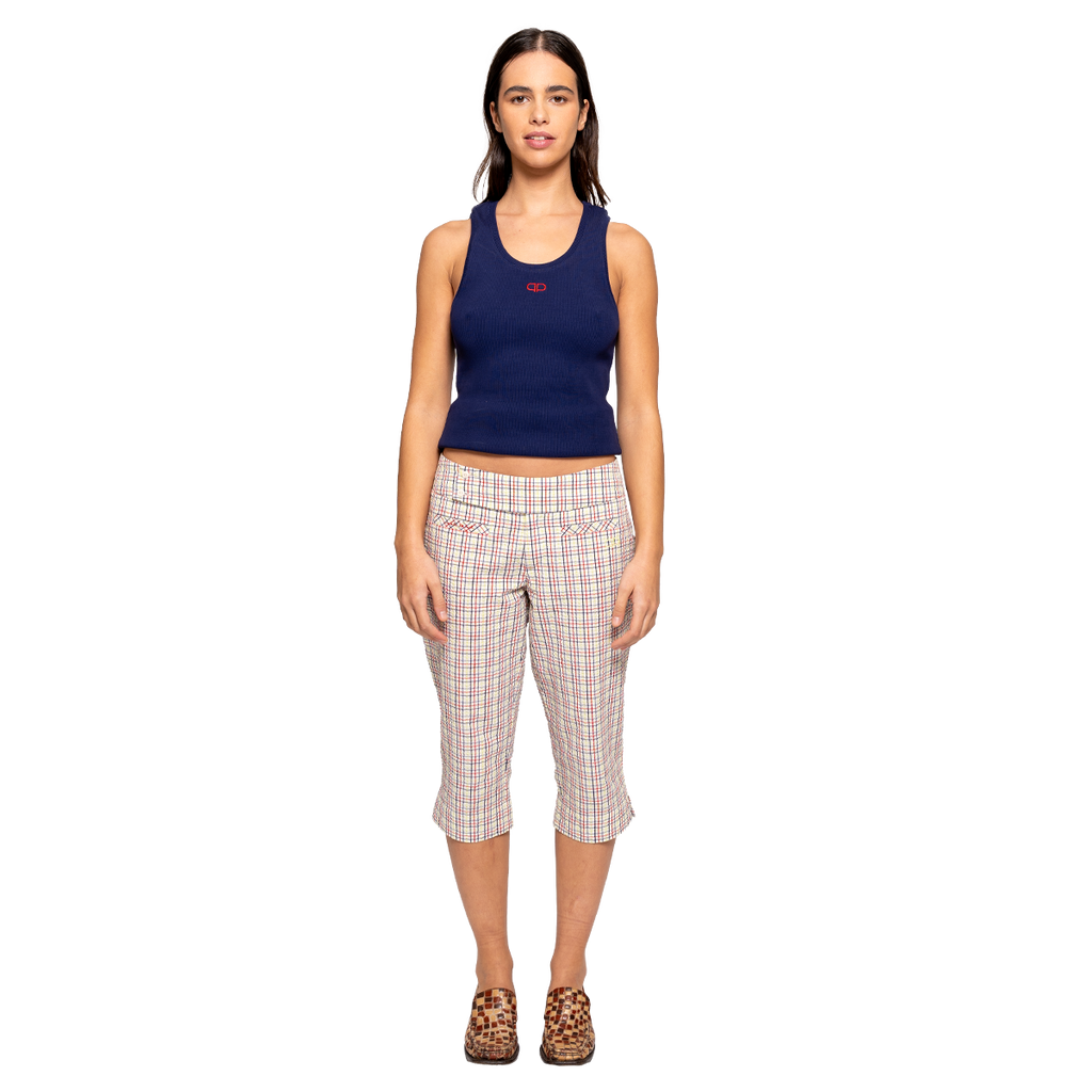 Woman wearing a navy tank top and plaid capri pants on a white background