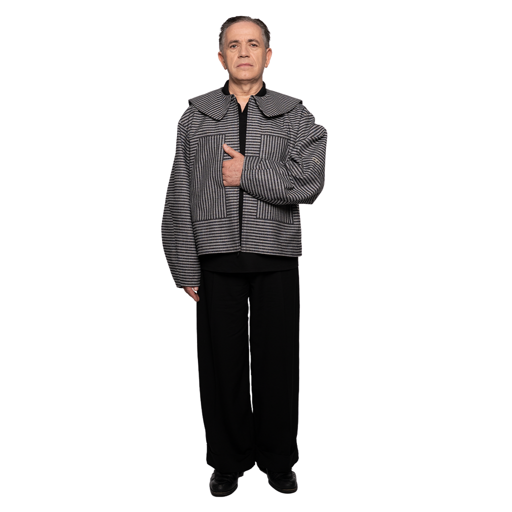 Person wearing a black and grey striped jacket on a white background