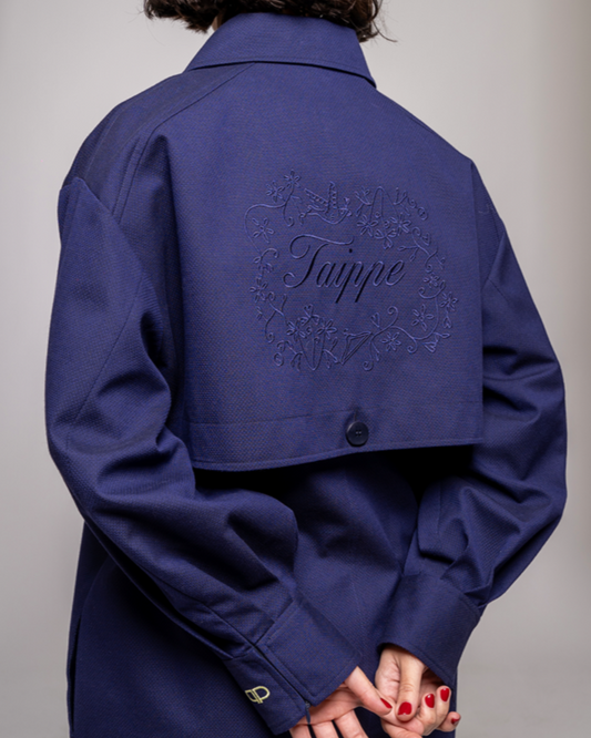 Navy blue coat with embroidery on a plain background