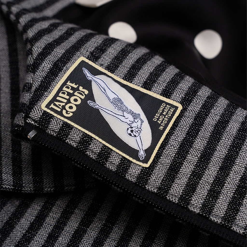 Close-up of a black and white striped fabric with a visible brand label.