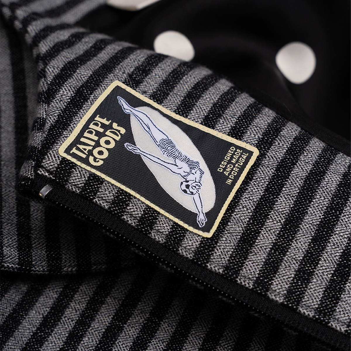 Close-up of a black and white striped fabric with a visible brand label.