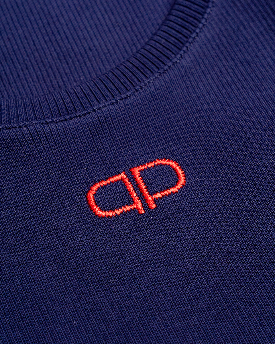 Close-up of a navy tank top with a red logo on a plain background