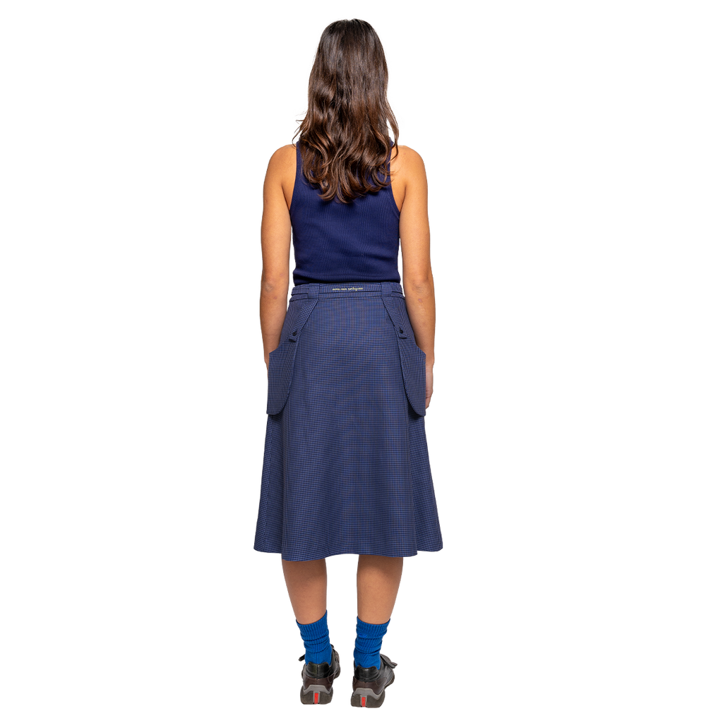 Woman wearing a blue skirt with pockets on a white background
