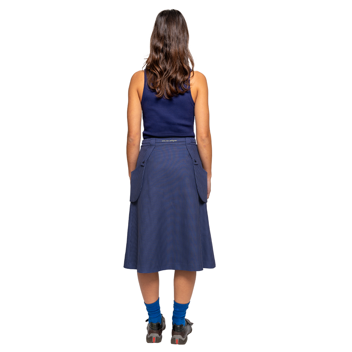 Woman wearing a blue skirt with pockets on a white background