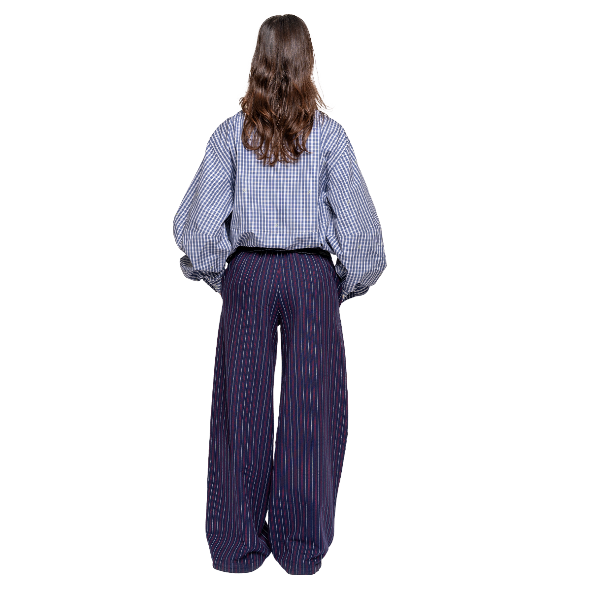 Person wearing a checkered shirt and striped pants on a white background
