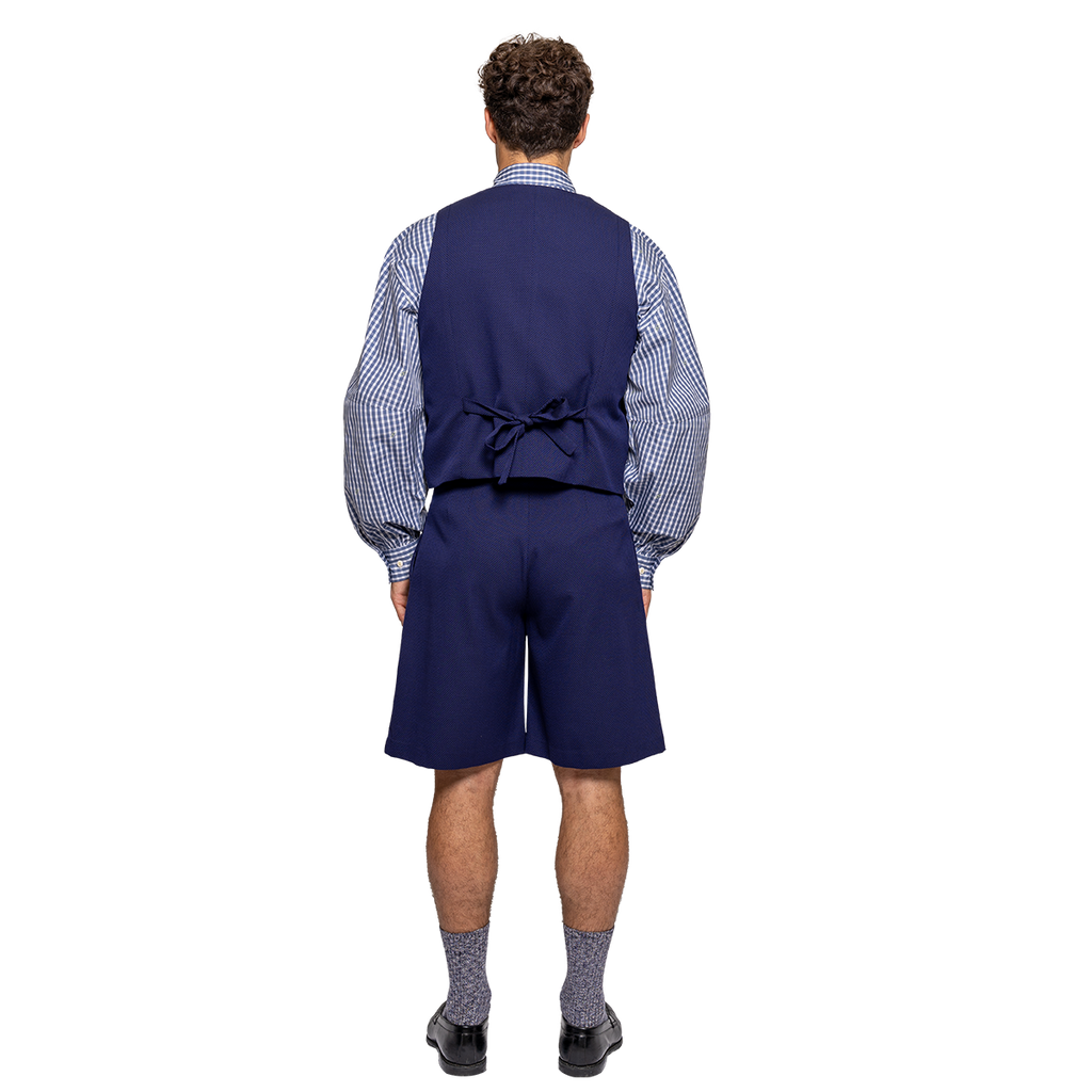 Person wearing a blue vest, checkered shirt, and shorts on a white background