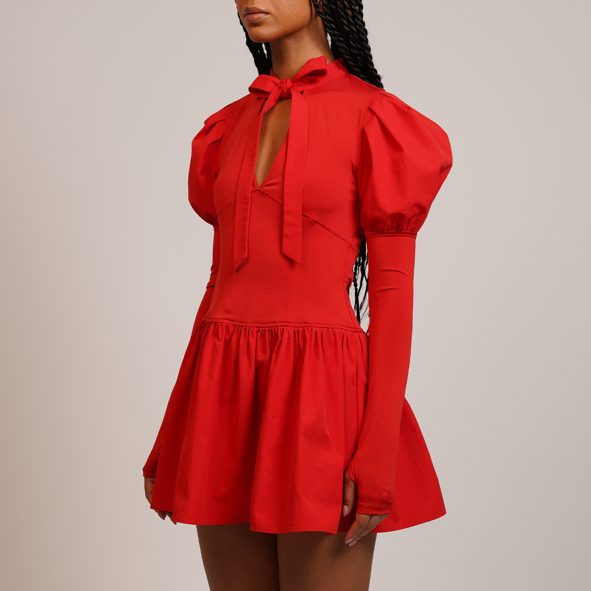 Red dress with puff sleeves and a bow neckline on a neutral background