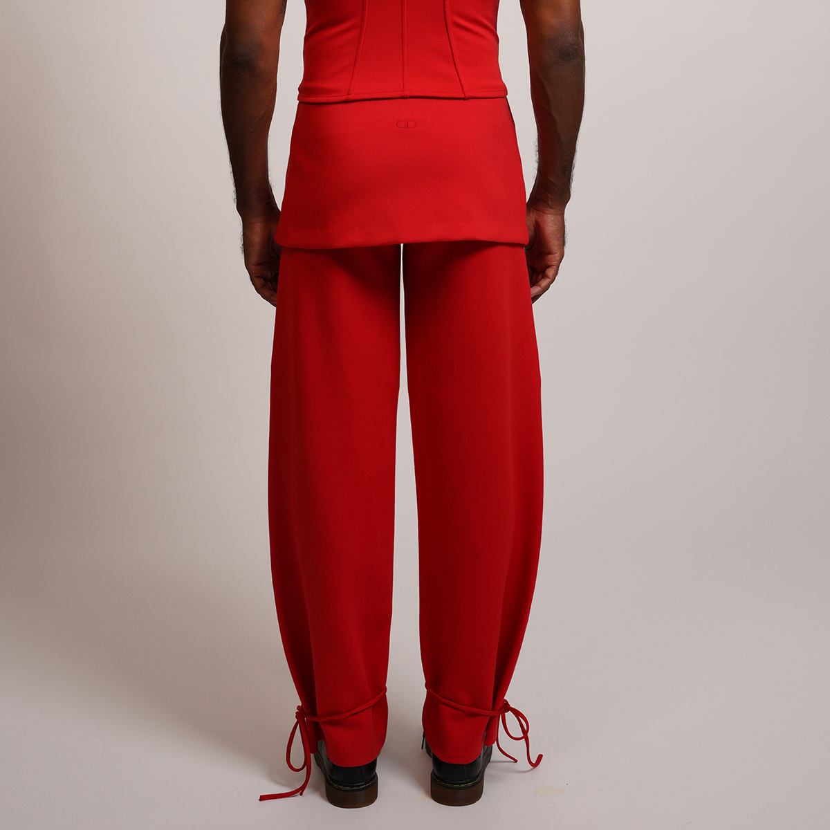 Person wearing a red outfit with wide leg pants 