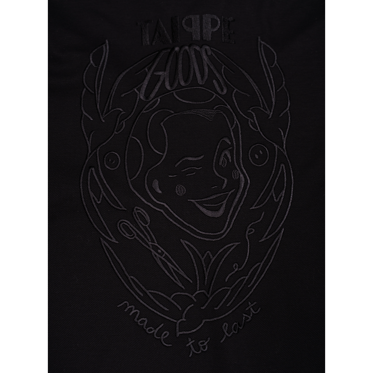Black t-shirt with black embroidered design and text on a white background