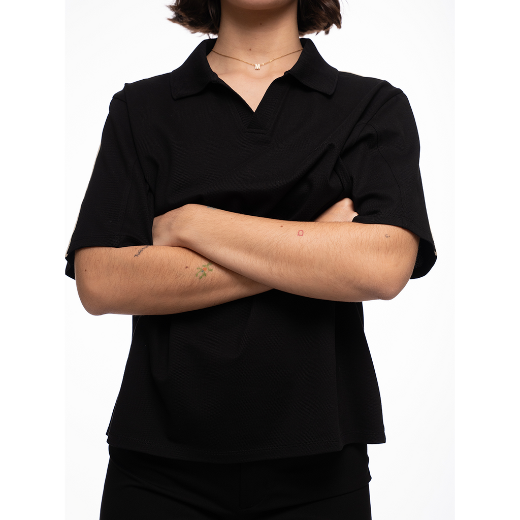 Person wearing a black shirt with arms crossed on a white background