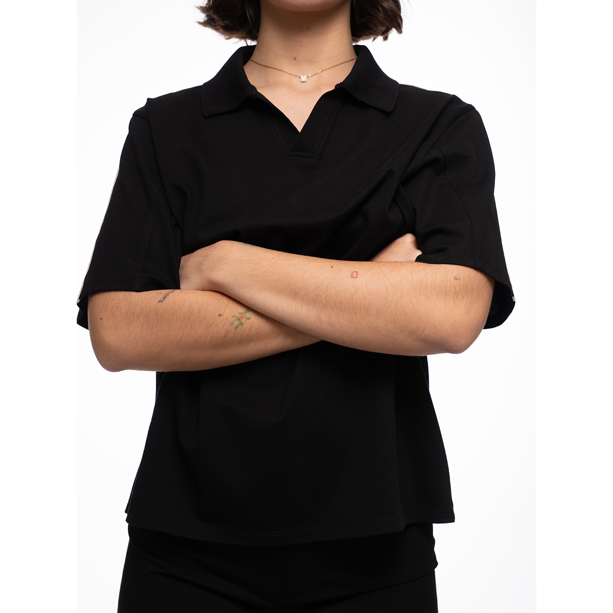 Person wearing a black shirt with arms crossed on a white background