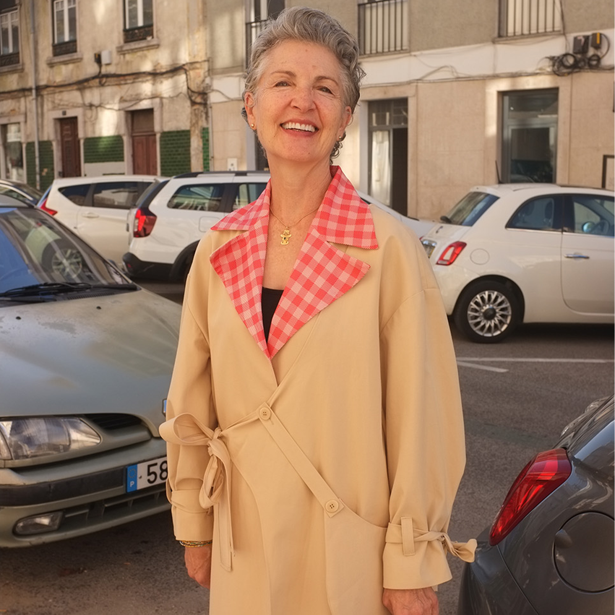 Woman in a beige trench coat with a red checkered collar 