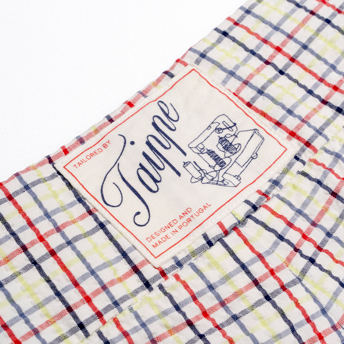 Fabric with a checkered pattern and Tailor by Taippe label.