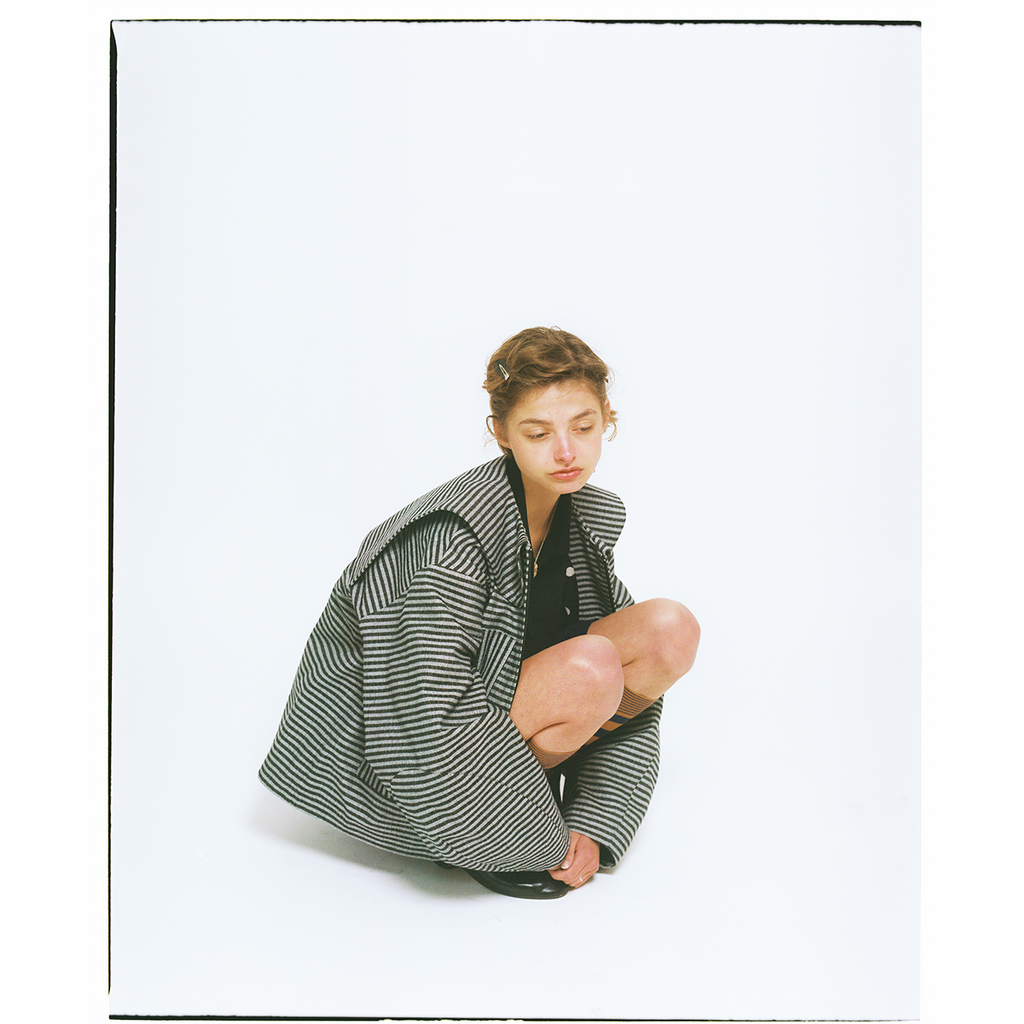 Person wearing a large striped jacket  on a white background