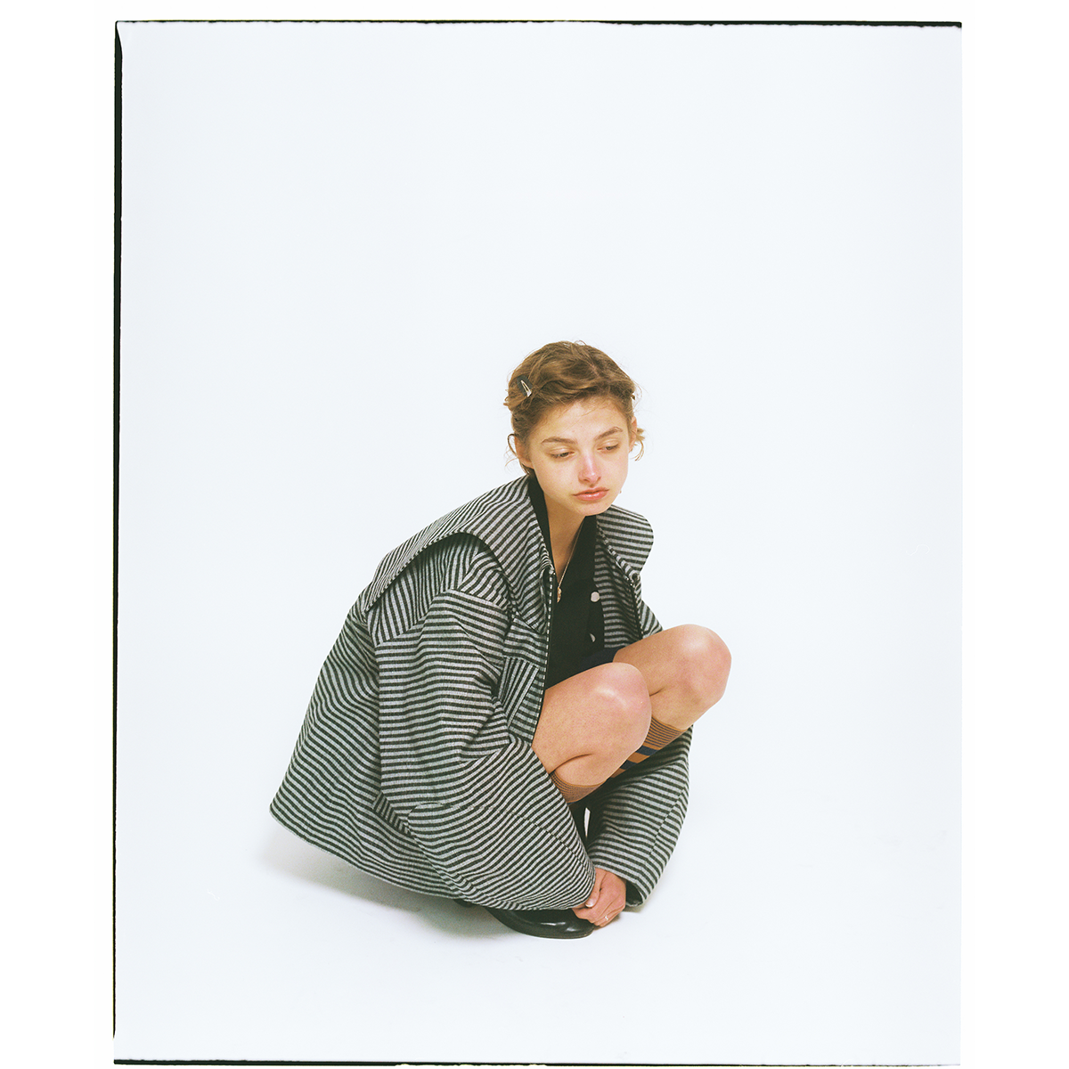 Person wearing a large striped jacket  on a white background