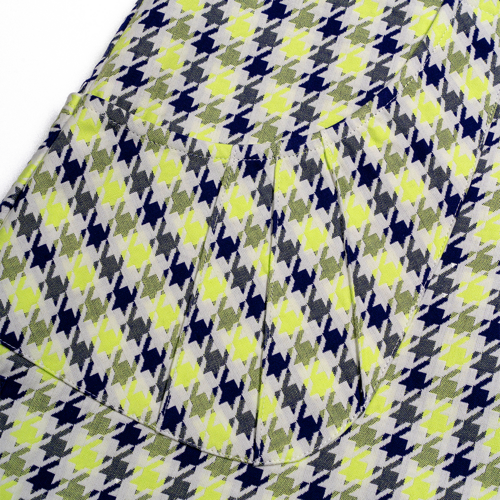 Close-up of a houndstooth pattern fabric with green, blue, and gray colors.