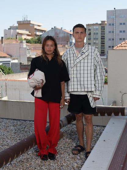 Two people standing on a rooftop with buildings in the background