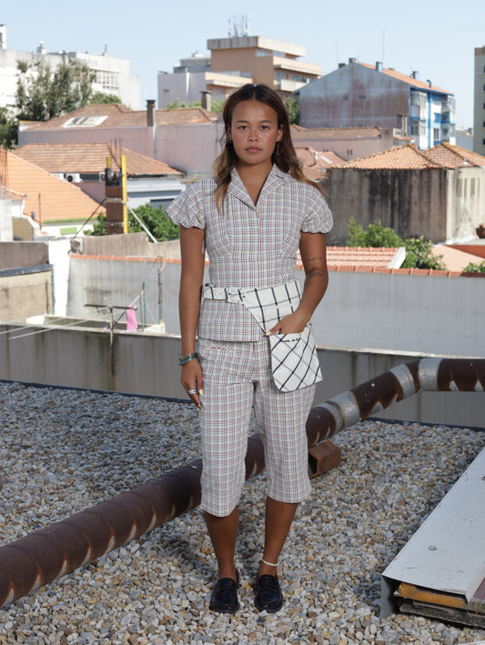 Woman standing on a rooftop with buildings and sky in the background