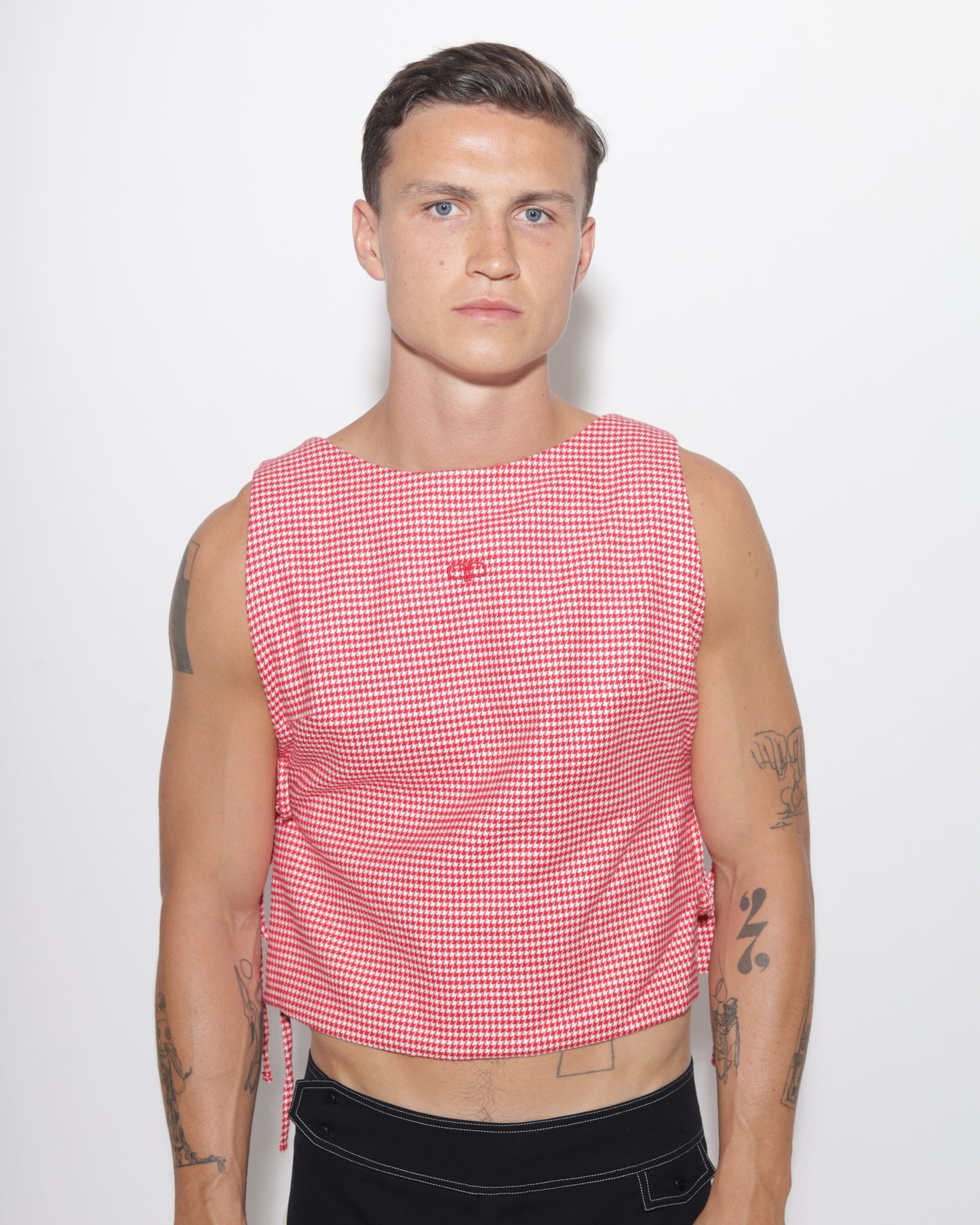 Person wearing a red and white checkered vest on a white background