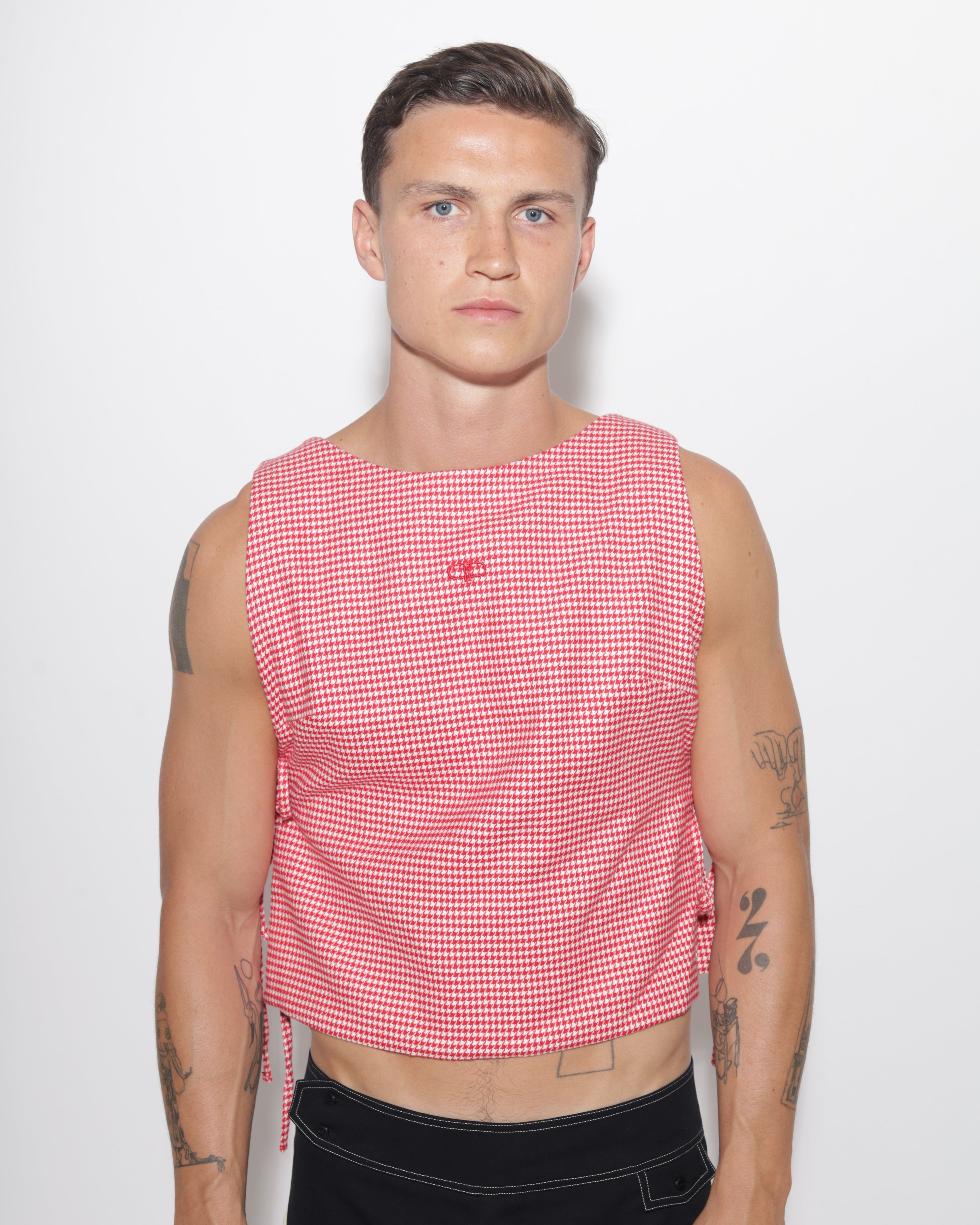 Person wearing a red and white checkered vest on a white background