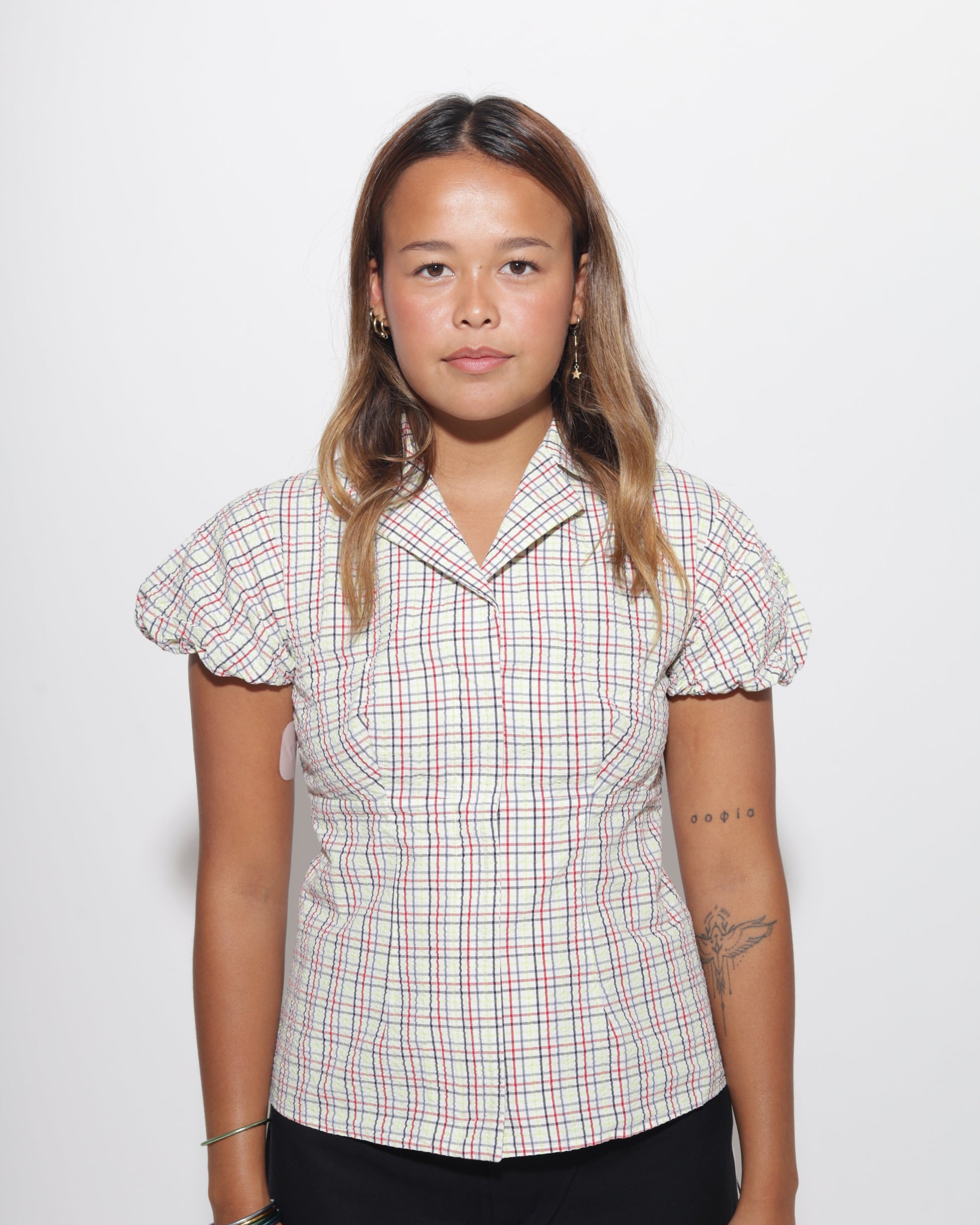 Woman wearing a plaid blouse on a white background