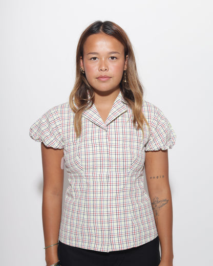 Woman wearing a plaid blouse on a white background