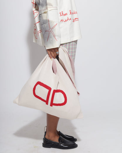 Person holding a white bag with red logo.