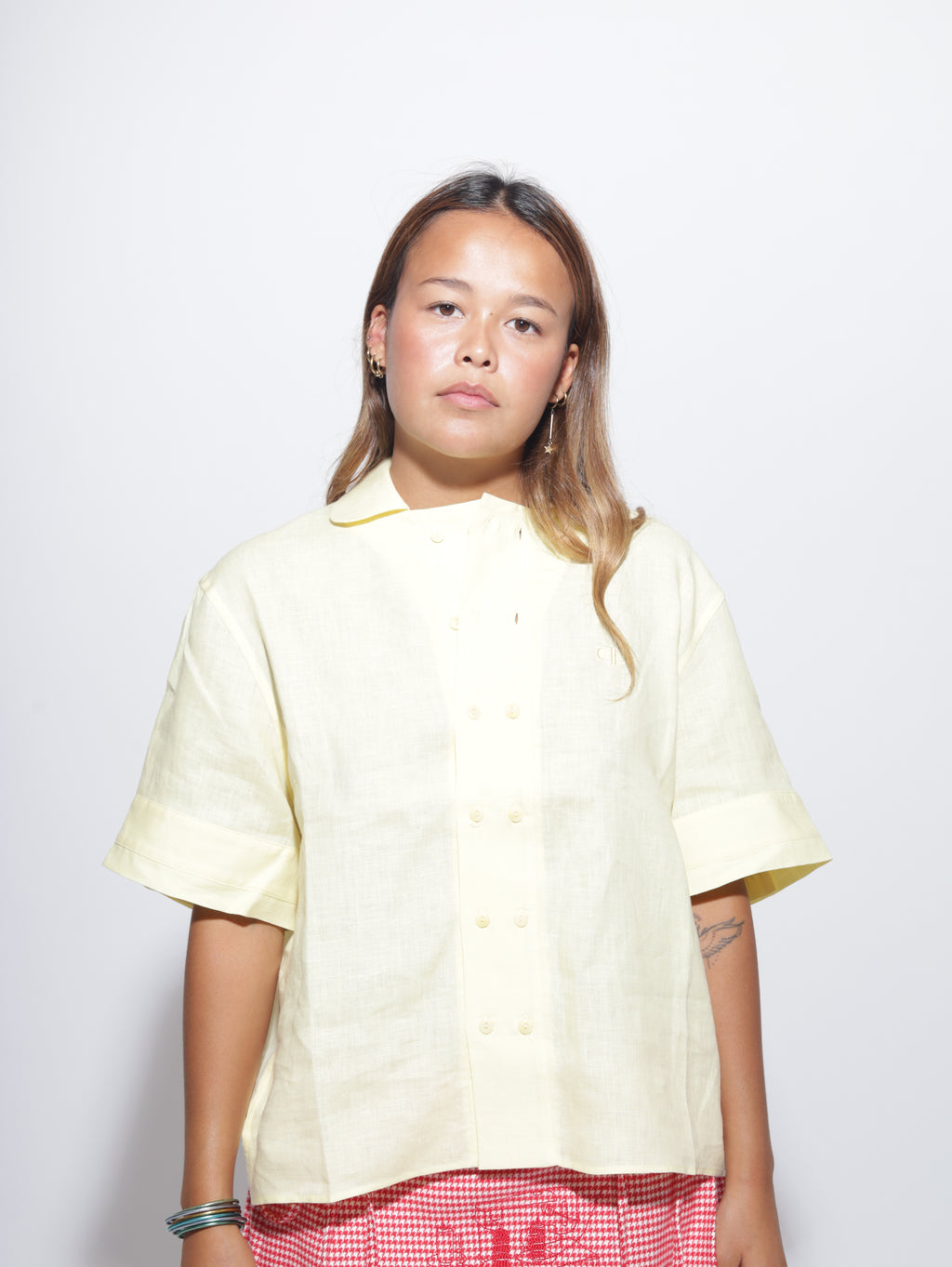 Woman wearing a light yellow button up shirt