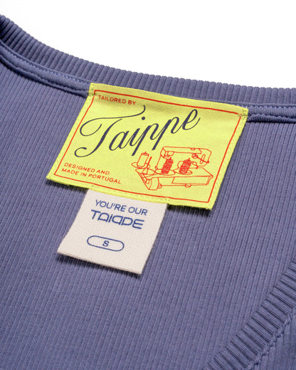 Close-up of a blue tank top with a yellow tag featuring the brand 'Taippe'.