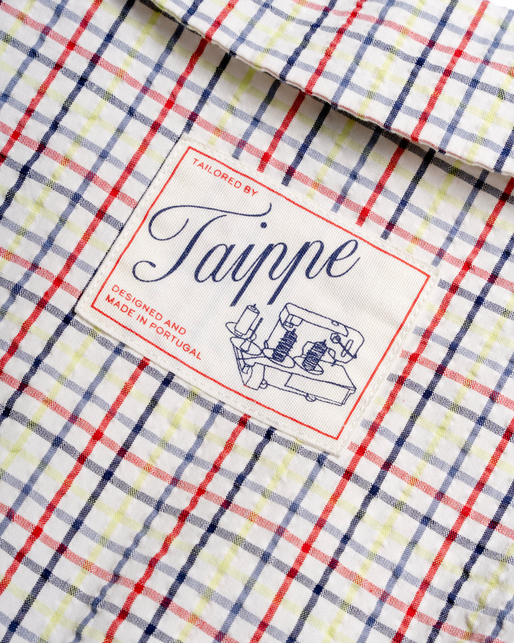Close-up of a checkered blouse with a 'Taippe' label 